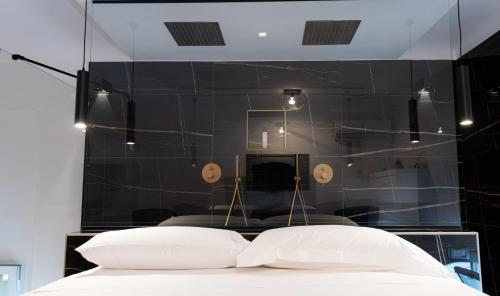 a bedroom with a black wall and a bed with two pillows at Wal49 Suite in Bari
