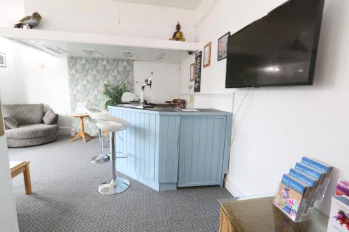 sala de estar con armario azul y TV de pantalla plana en Sunnydene, en Great Yarmouth
