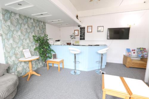 una sala de espera con un mostrador azul y taburetes en Sunnydene, en Great Yarmouth
