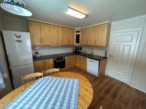 a kitchen with a table and a white refrigerator at Enesi holiday house 