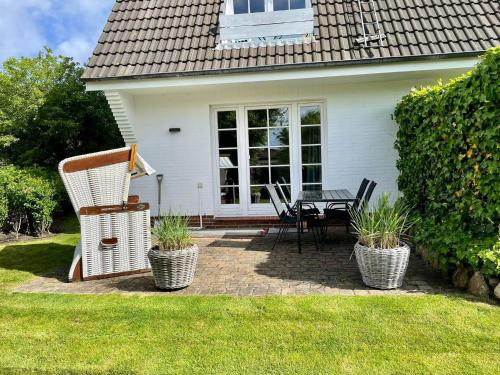 a patio with a table and chairs in front of a house at Appartment Düne in Westerland