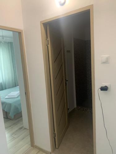 a door leading to a bedroom with a bed at NELI HOME Apartament in Reghin