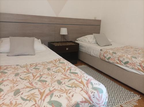 um quarto com 2 camas e uma mesa com um candeeiro em Villas Arbia - Rio by the Beach em Rab