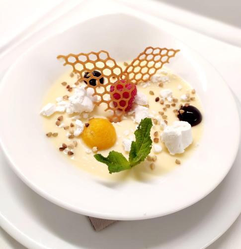 a white plate with a dessert in the shape of a butterfly at Hotel & Chalets Edelweiss in Madonna