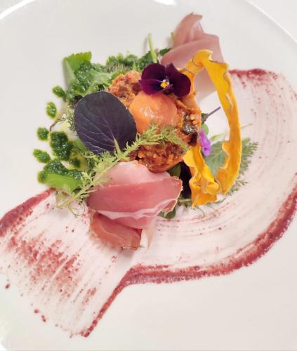 a plate of food with vegetables on a fork at Hotel & Chalets Edelweiss in Madonna