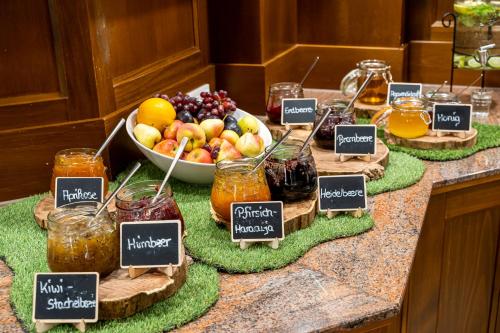 Ein Tisch voller Gläser mit Früchten und einer Schüssel mit Fruchtsaft. in der Unterkunft Waldhotel Tannenhäuschen in Wesel
