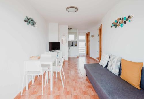 ein Wohnzimmer mit einem Tisch und einem Sofa in der Unterkunft Apartamento Maypa 2 Salitre in Meloneras