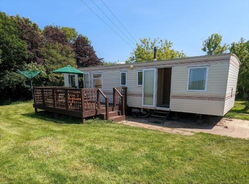 a mobile home with a porch and a deck at Glebe Farm Holidays in Newport