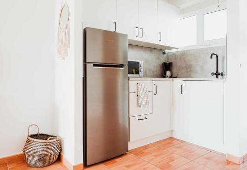 a stainless steel refrigerator in a kitchen with white cabinets at Apartamento Maypa 2 Salitre in Meloneras