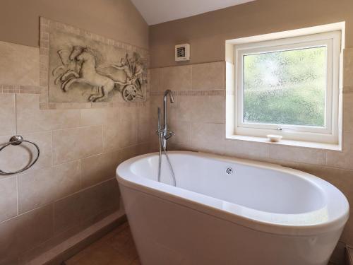 a bath tub in a bathroom with a window at Ellerbeck Bridge in Kendal