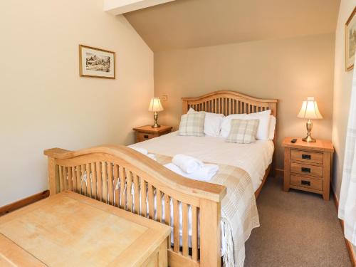 a bedroom with a wooden bed and two lamps at Ellerbeck Bridge in Kendal