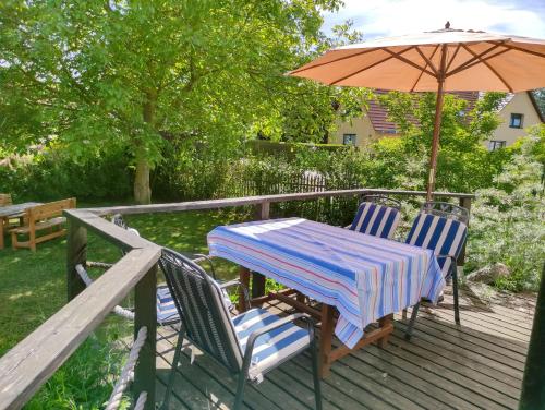 a table and chairs with an umbrella on a deck at Ferienhof Kestermann in Neppermin