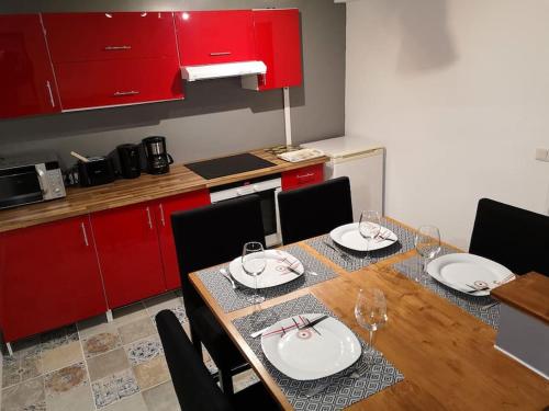 une salle à manger avec une table et des armoires rouges dans l'établissement Appartement La Maison de UR - Cerdagne, à Ur