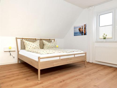 uma cama num quarto branco com uma janela em Haffblick em Insel Poel