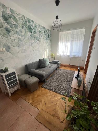 ein Wohnzimmer mit einem Sofa und einem Teppich in der Unterkunft Luca Vendégház 1. apartman in Sárvár