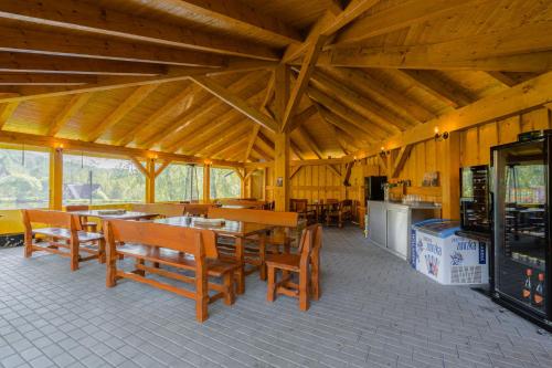 a dining room with wooden tables and chairs in a cabin at Apartmány Nad rybníky in Horní Planá