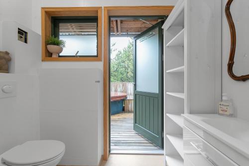 a bathroom with a toilet and a door to a porch at Gesthus Selfoss in Selfoss