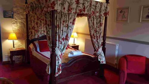 een slaapkamer met een hemelbed in een kamer bij The Walnut Tree in Yeovil