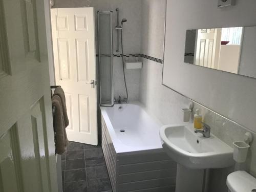 a white bathroom with a sink and a shower at Frankies Flat, a Superb apartment in Flamborough. in Flamborough