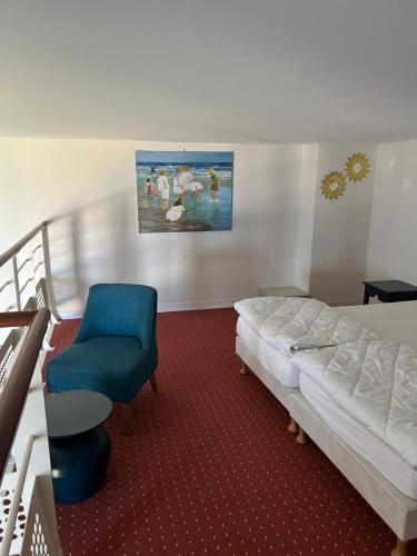 une chambre avec un lit et une chaise bleue dans l'établissement Les yeux dans l'océan, au Croisic