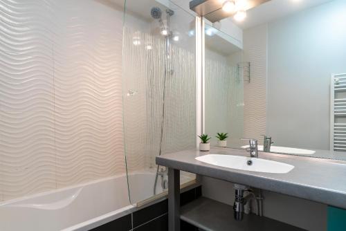 a bathroom with a sink and a shower at Les Thermes 515 - Appt avec piscine partagée in Concarneau