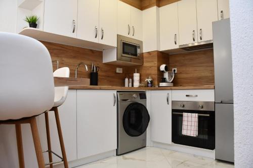 een keuken met witte kasten en een vaatwasser bij Comfort 37 - Luxury ski apartment near the gondola in Bansko