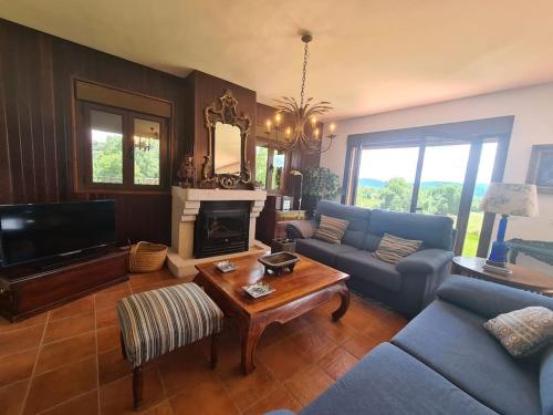 a living room with a couch and a fireplace at Villa Juan in La Adrada