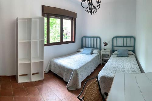 um quarto com 2 camas e uma janela em Villa Juan em La Adrada