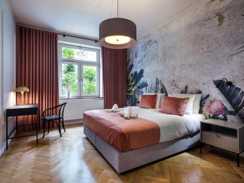 a bedroom with a bed and a desk and a window at Tyzenhauz Grand Apartaments in Kraków