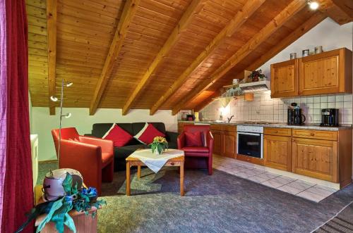 eine Küche und ein Wohnzimmer mit einem Sofa und einem Tisch in der Unterkunft Ferienwohnungen am Weberfeld in Bodenmais