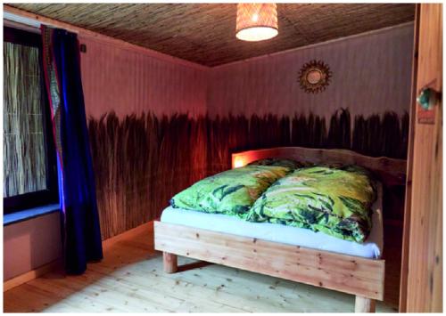 a bed in a room with a red wall at Elfenhütte Ferienhaus Eifel in Rott
