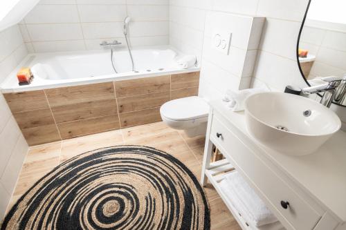 a bathroom with a tub and a toilet and a sink at Villa GreenTree - with Private Pool, close to Budapest in Budakalász