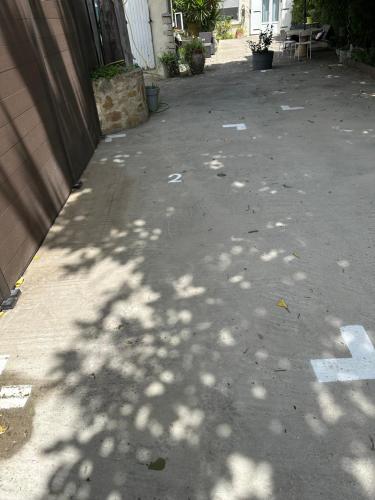 an empty alley with a building and a shadow of a tree at La lavande in Arles