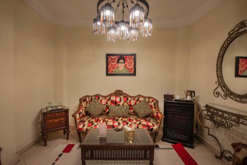 a living room with a couch and a chandelier at Le Riad Hotel de Charme in Cairo