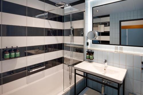 a bathroom with a shower and a sink and a mirror at Crowne Plaza Antwerpen, an IHG Hotel in Antwerp
