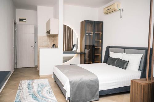 a bedroom with a large white bed and a kitchen at Guest House Fjolla in Ulcinj