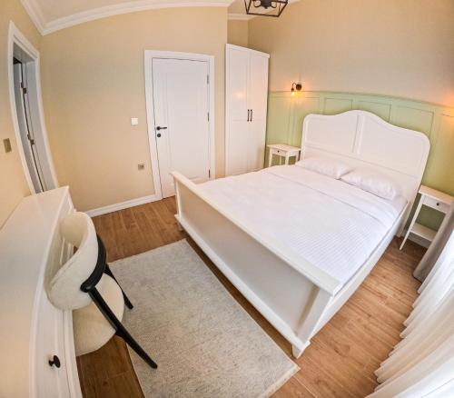 1 dormitorio con cama blanca y alfombra blanca en Suit Rabando Uzungöl, en Uzungöl