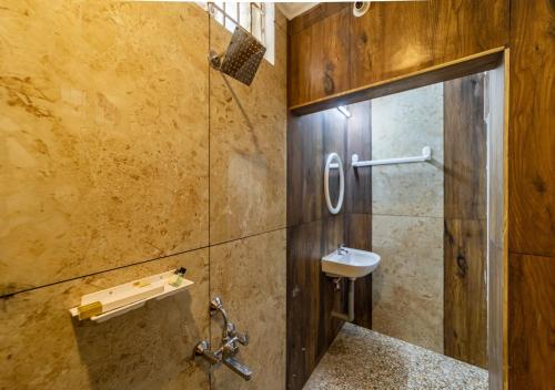 a bathroom with a shower with a sink and a toilet at Yellow Residency in Puducherry