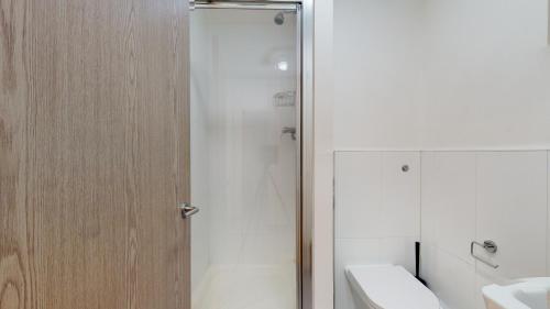 a bathroom with a shower with a toilet and a sink at Superb Studio Apartment in London