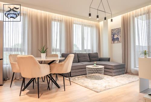 un soggiorno con un divano, un tavolo e delle sedie di Urban Exec Suite with Free Gym Pass, Full Office Setup and Designated Parking Space a Plovdiv