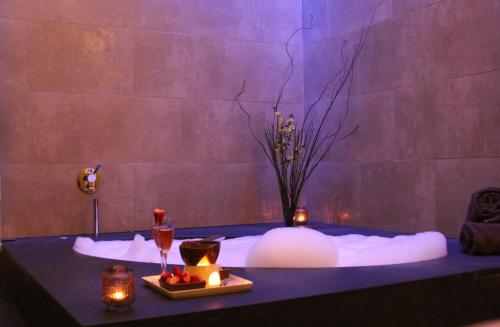 a room with a bath tub with candles and a table at Vilamoura Garden Hotel in Vilamoura