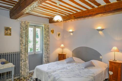 sypialnia z łóżkiem i oknem w obiekcie Chambres d'hôtes "Le Colombier" w mieście Venasque