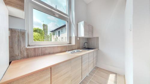 uma cozinha com um lavatório e uma janela em ZIELONY ZAKĄTEK Apartament w centrum przy Agorze em Bytom