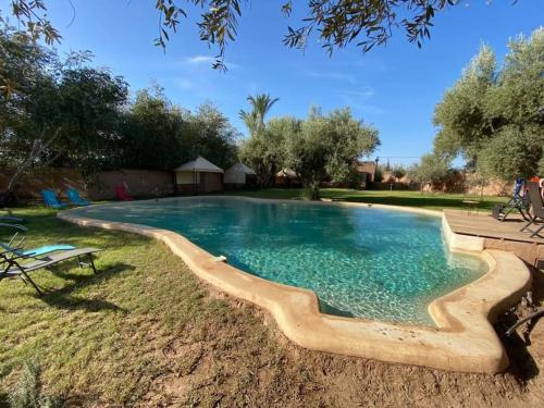 einen Pool mit Holzkoppelung im Hof in der Unterkunft Riad salix d'agafay in Marrakesch