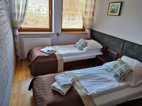 a room with two beds and two windows at Apartament HANIA in Zakopane