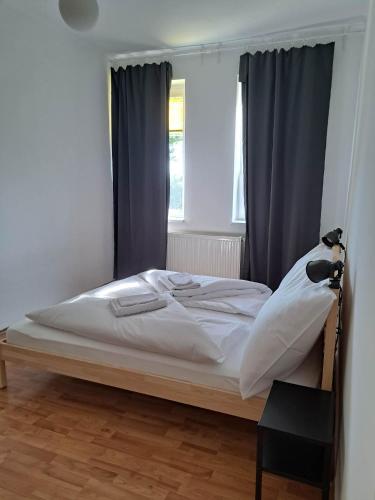a white bed in a room with a window at Tarcal Apartman in Tarcal