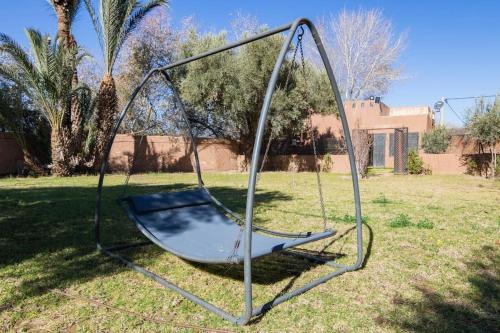 a metal swing in a field with a yard at Douiria salix agafay in Marrakech