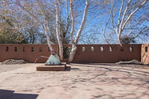 a fence with a tree in front of a building at Douiria salix agafay in Marrakech