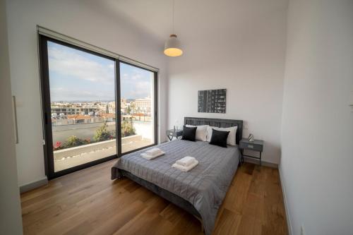 a bedroom with a bed and a large window at Premier 401 3 bedroom penthouse in Paphos City