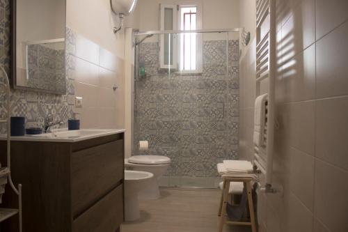 y baño con aseo, lavabo y ducha. en Appartamento via Roma, en Recale